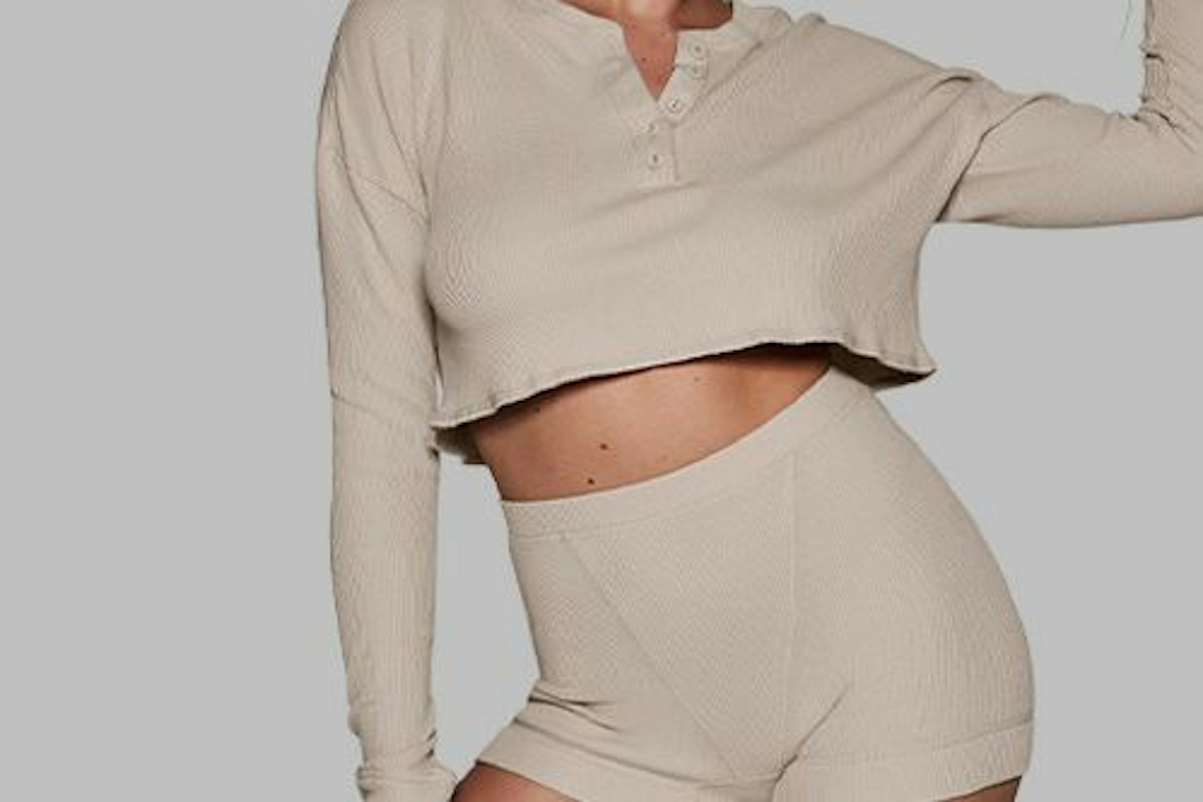 A cropped cream henley top styled with matching shorts
